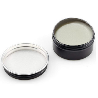 A small open jar of mink oil for cowboy boots, showing the cream-colored oil inside.