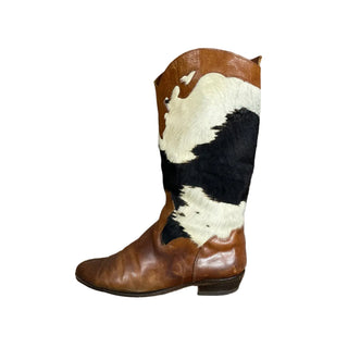 Brown leather boot with black and white cowhide pattern on a white floor.