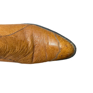 Brown leather shoe on a white floor