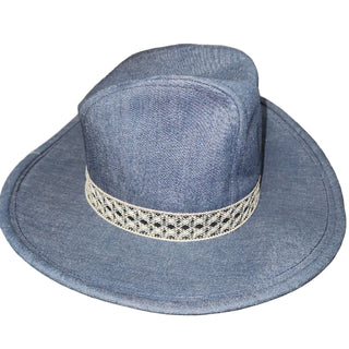 Blue denim hat with a decorative band on a white surface