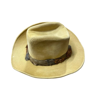 Beige hat with feather accents on a wooden surface