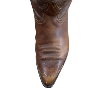 Brown leather boot on a wooden floor