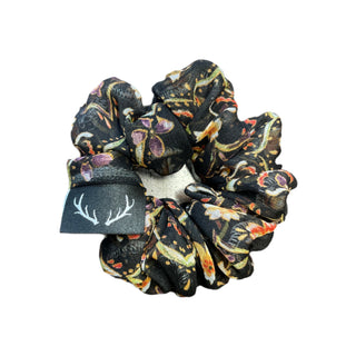 Floral patterned scrunchie with a brand tag on a white background
