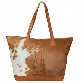 Brown tote bag with cow print and tassels on a white background