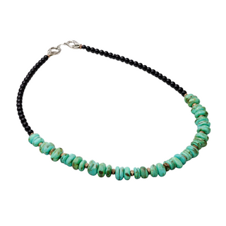 Necklace with turquoise beads and black cord on a white background