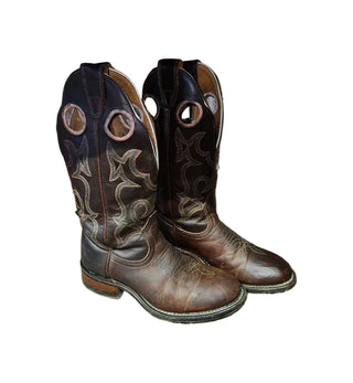 Pair of brown cowboy boots with intricate designs on a white surface.