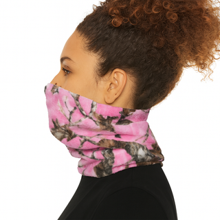 Person wearing a pink and black camouflage neck gaiter on a white background