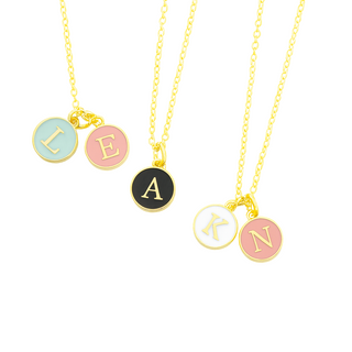 Three gold necklaces with round letter charms on a white background