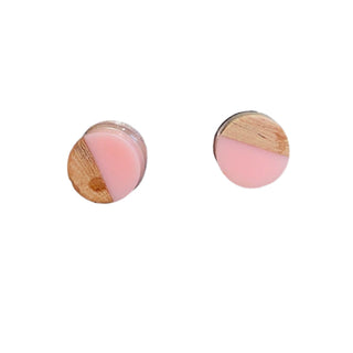 Pair of round earrings with pink and wooden design on a white background