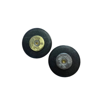 Two black resins bullet casings with brass and metal components on a white background