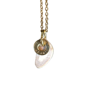 A necklace with a gold chain and a pendant that appears to be a shed antler slice attached to a small circular charm with the brand name Bullet Name